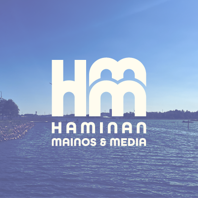 Haminan mainos ja media logo merimaisemaa kuvaavan valokuvan päällä.